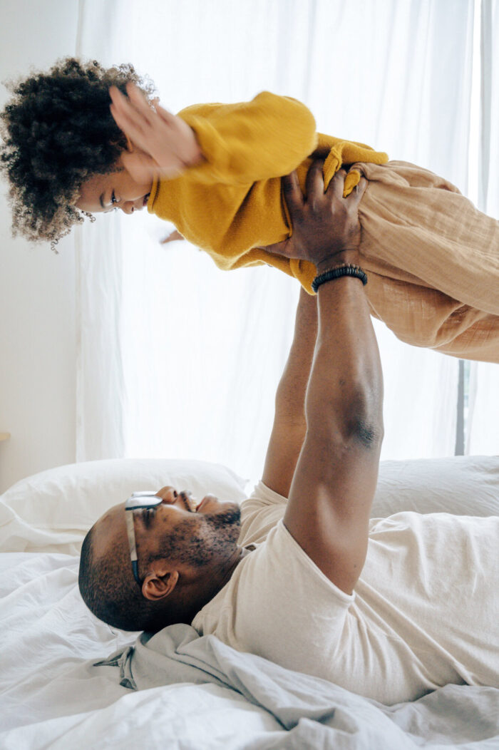 Father lifting happy child up above him