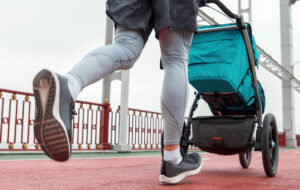 A mother pushes a stroller while jogging