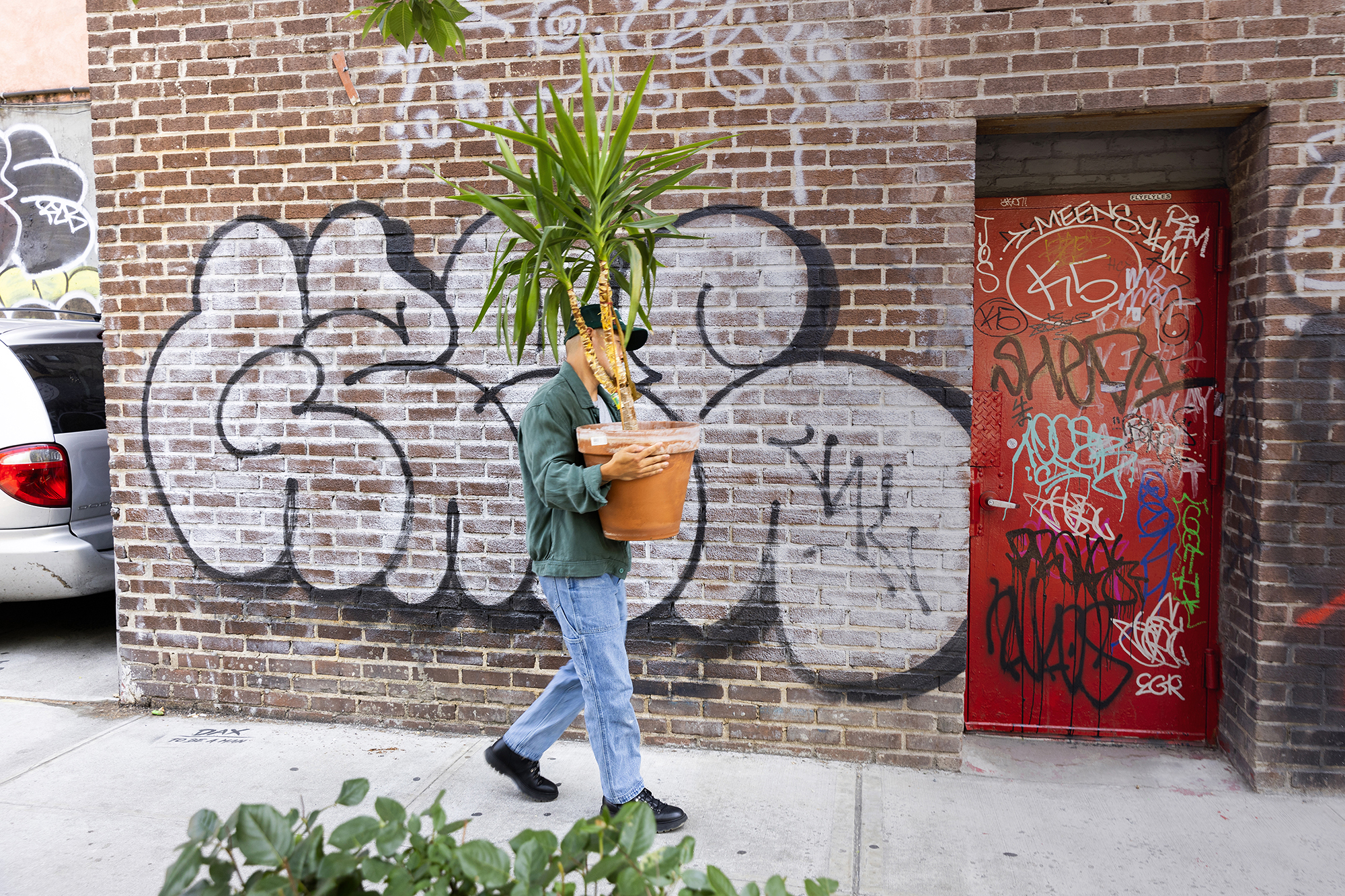 A person walking down a sidewalk holding flowers