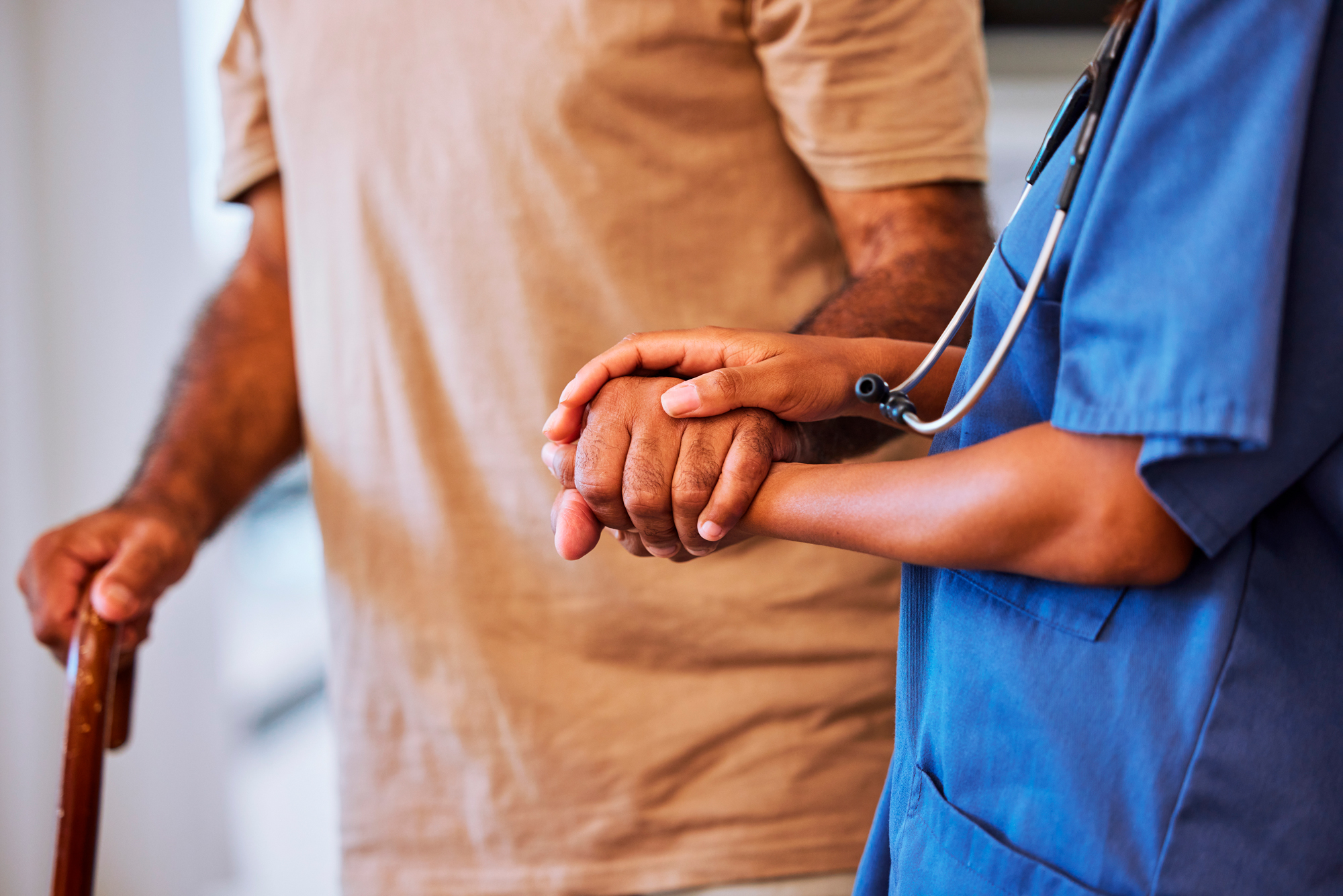 Support, trust and help from caregiver or nurse walking with senior man or patient in retirement home with healthcare insurance. Hands of female medical worker and alzheimers male with hospice care